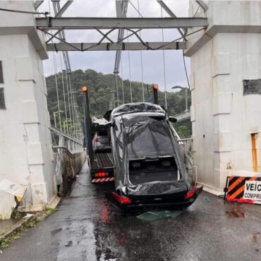 caminhao-cegonha-fica-entalado-ao-tentar-passar-por-ponte-no-litoral-de-sp;-carro-transportado-e-destruido